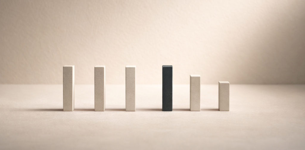 Minimalist editorial still life with aligned vertical markers, one subtly offset, symbolizing signal interpretation and pattern recognition within economic systems.